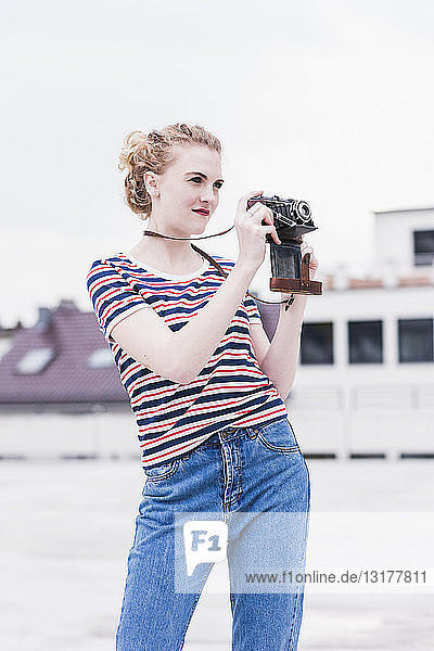 Porträt einer jungen Frau mit Oldtimer-Kamera