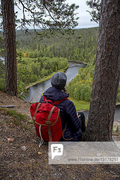 Finnland  Oulanka-Nationalpark  Frau mit Rucksack in unberührter Natur sitzend