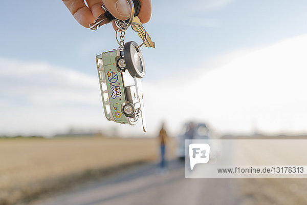 Wohnmobilschlüssel in der Hand haltend in ländlicher Landschaft