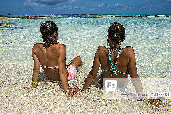 Karibik  Kolumbien  San Andres  El Acuario  Rückansicht von zwei Frauen  die in flachem Wasser sitzen
