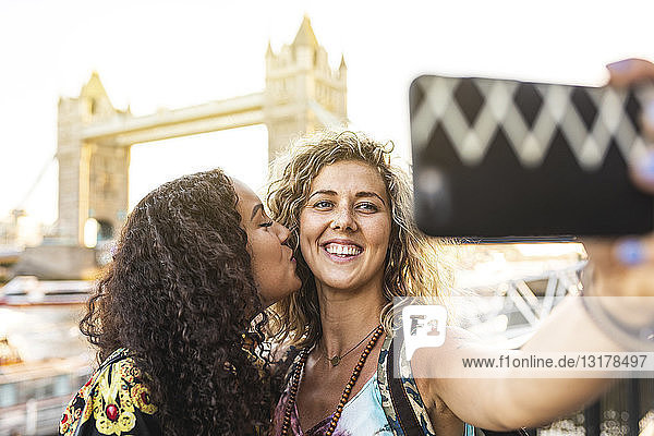 UK  London  two friends taking a selfie with Tower Bridge in background