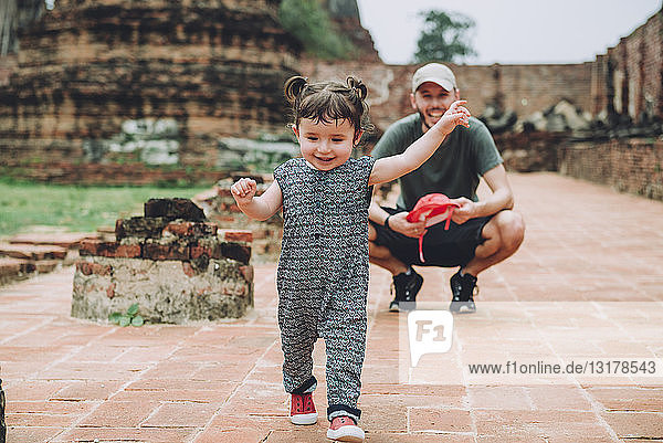 Thailand  Ayutthaya  Vater beobachtet sein kleines Mädchen beim Spaziergang in den alten Ruinen eines Tempels im Wat Mahathat