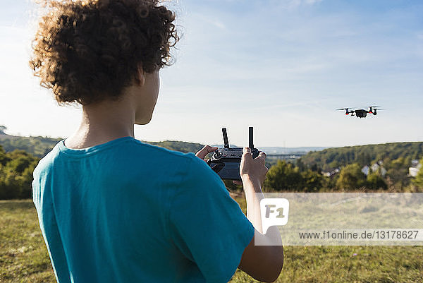 Boy navigating a flying drone outdoors