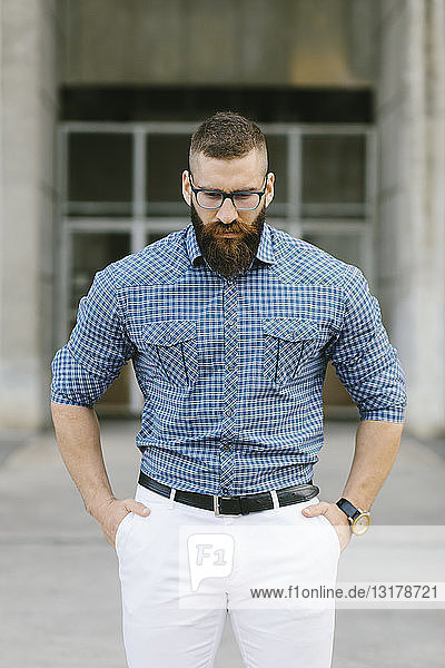 Portrait of bearded hipster businessman wearing glasses and plaid shirt