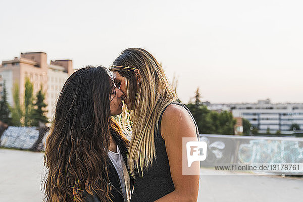 Lesbisches Paar küsst sich in der Stadt