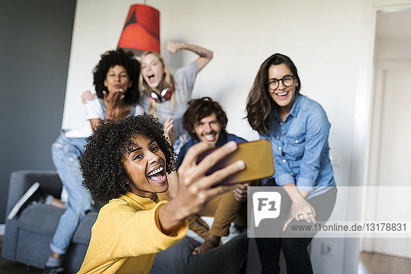Cheerful friends taking a selfie at home
