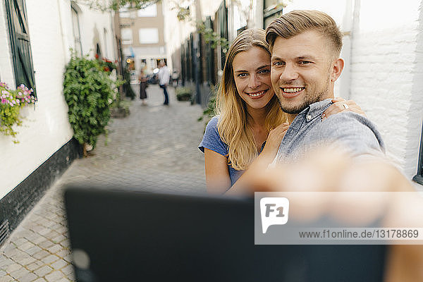 Niederlande  Maastricht  glückliches junges Paar  das in der Stadt ein Selfie macht