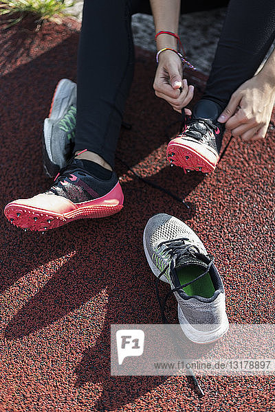 Teenage girl changing shoes for running training