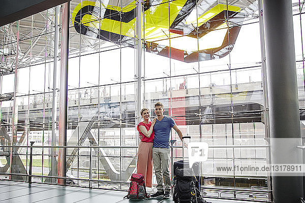 Smiling couple standing at the airport