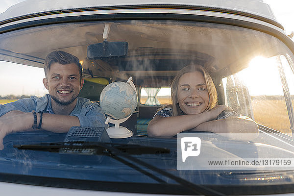 Porträt eines glücklichen jungen Paares auf einer Reise im Wohnmobil