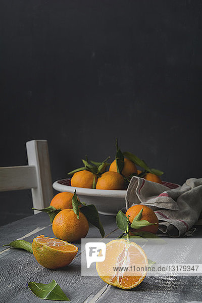 Sliced and whole tangerines on wooden table