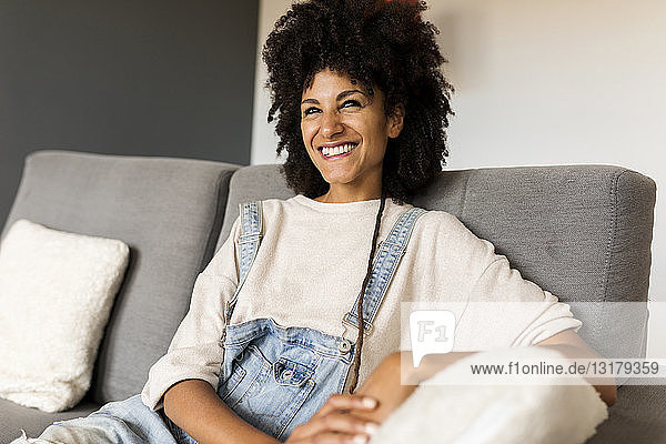 Porträt einer glücklichen Frau  die zu Hause auf der Couch sitzt