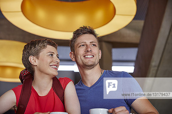 Lächelndes Paar mit Rucksack in einem Cafe