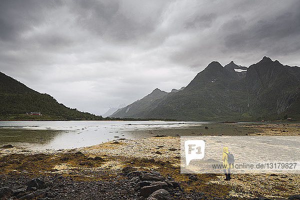 Junger Mann steht an einem See auf der Insel Vesteralen  Lappland  Norwegen