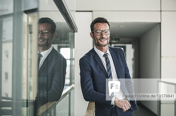 Porträt eines erfolgreichen Geschäftsmannes  stehend im Bürogebäude