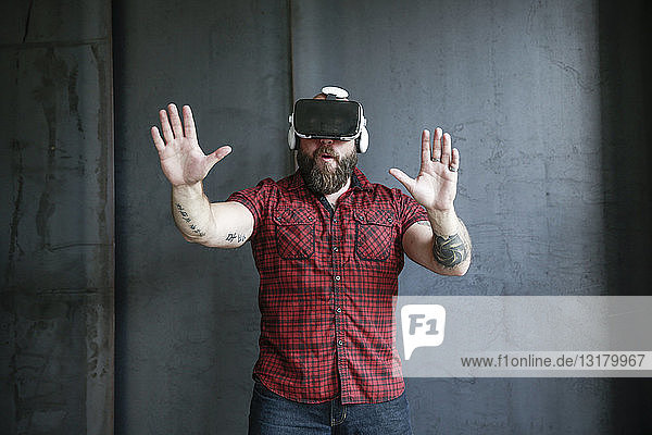 Aufgeregter bärtiger Mann mit VR-Brille