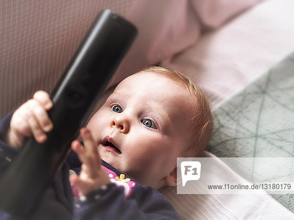 Baby girl holding remote control