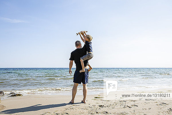 Vater und Sohn spielen am Strand