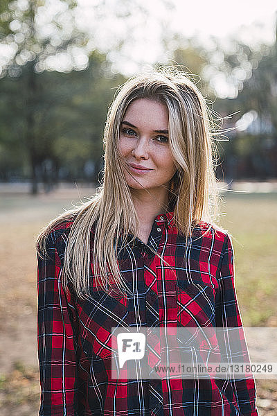 Portrait of blond young woman wearing plaid shirt in autumn