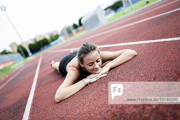 Teenage runner relaxing on race track  after training