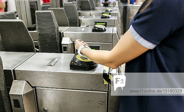 Junge Frau bezahlt mit ihrer Smartwatch in der U-Bahn  Teilansicht