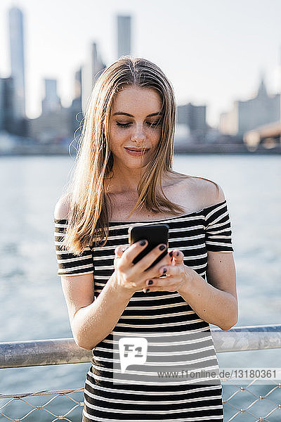 USA  New York  Brooklyn  junge Frau betrachtet Smartphone