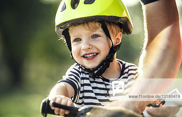 Porträt eines lächelnden Kleinkindes mit Fahrradhelm