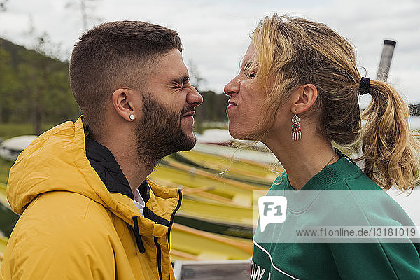 Finnland  Lappland  lustiges junges Paar beim Grimassieren am Seeufer