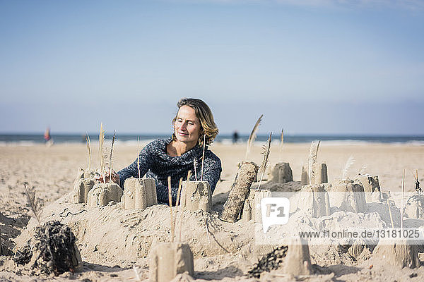 Mature woman building a sandcastle on the beach