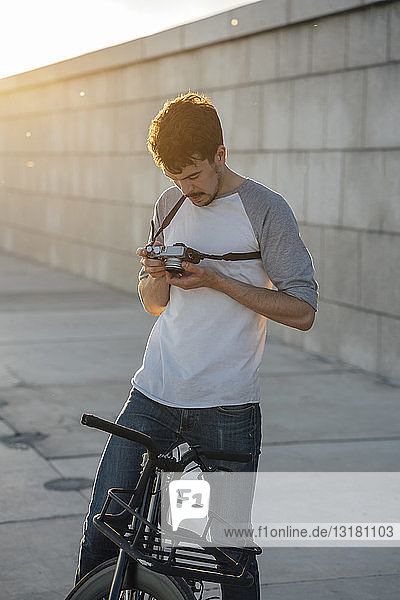 Junger Mann mit Pendler-Fixie-Fahrrad schaut in die Kamera