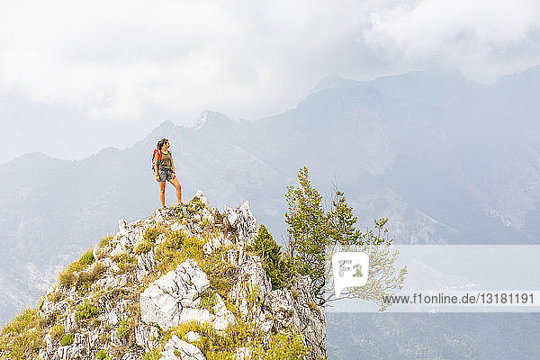 Italy  Massa  young woman standing on top of a peak in the Alpi Apuane mountains