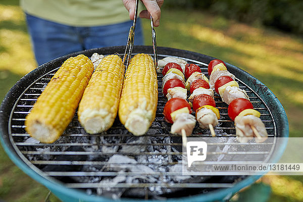Maiskolben und Fleischspieß auf dem Grill beim Barbecue im Garten