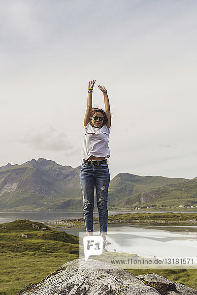 Junge Frau springt auf einen Felsen  Lappland  Norwegen