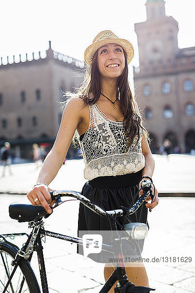 Italy  Bologna  portrait of fashionable young woman with bicycle in the city
