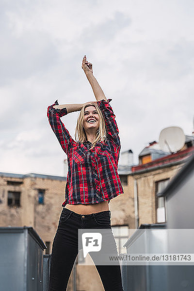 Modische junge Frau mit kariertem Hemd auf dem Dach