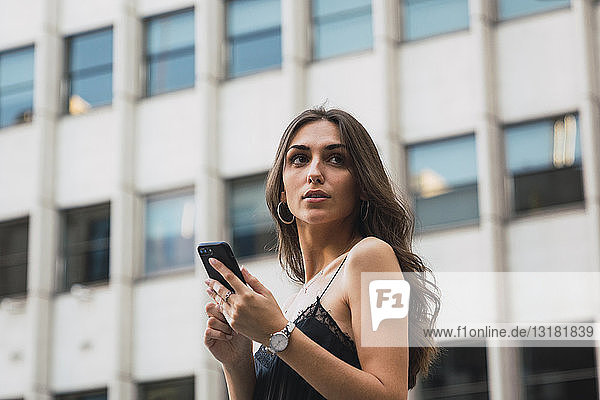 Portrait of young woman with cell phone waiting