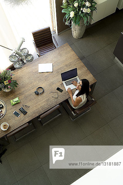 Overhead view of woman using laptop at home