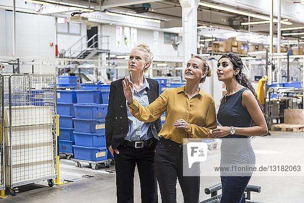 Drei Frauen im Gespräch in einer modernen Fabrik