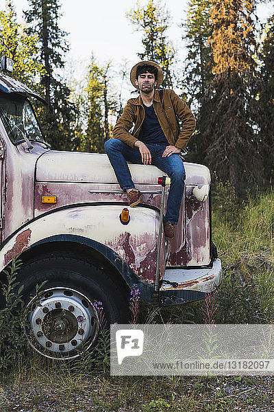 Cool young man sitting on a broken truck