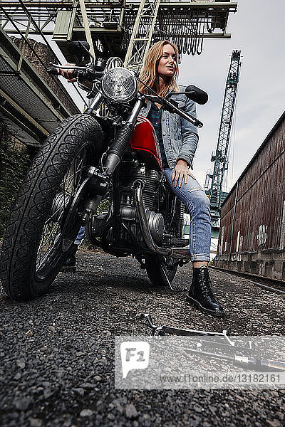 Porträt einer selbstbewussten jungen Frau auf Motorrad