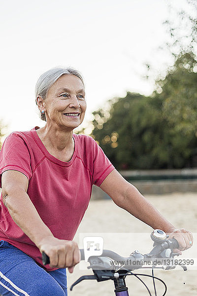 Portrait of smiling senior woman riding bicycle