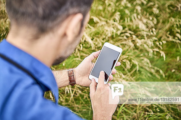 Close-up of man checking his cell phone during hiking trip