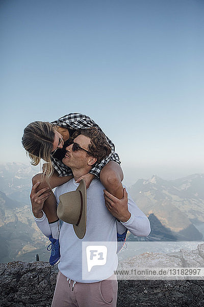 Schweiz  Grosser Mythen  junger Mann  der seine Freundin auf die Schultern küsst
