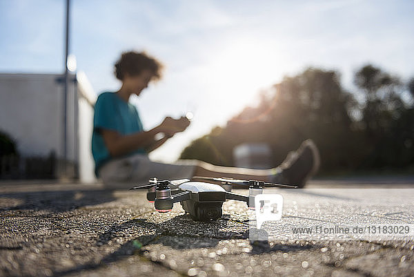 Boy landing his drone on the street