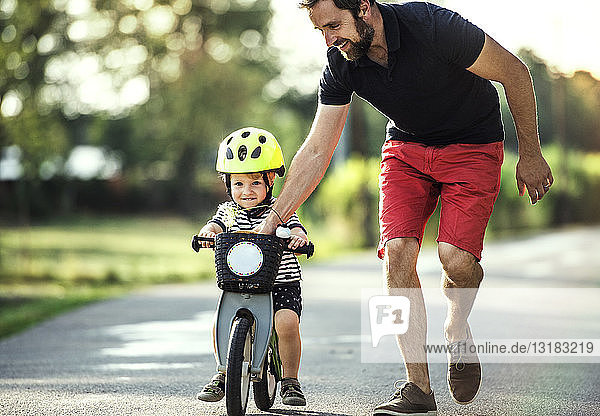 Vater unterrichtet kleinen Sohn beim Fahrradfahren
