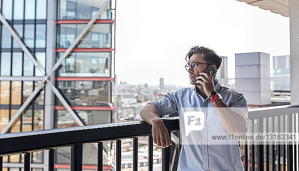 UK  London  man on the phone on a roof terrace