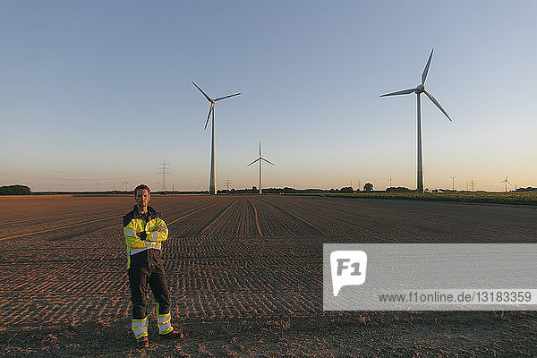 Ingenieur  der auf einem Feld eines Windparks steht