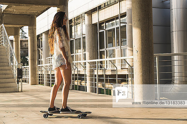 Junge Frau fährt Skateboard in der Stadt