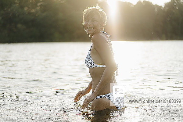 Portrait of happy woman wearing a bikini in a lake