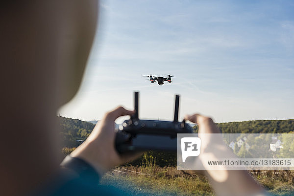 Boy navigating a flying drone outdoors